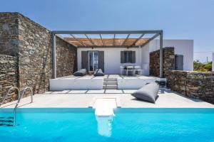 a villa with a swimming pool and a house at Windmills Kythnos in Kithnos