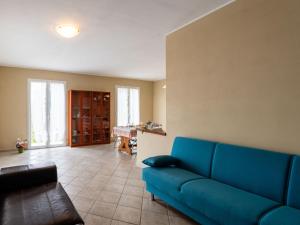 a living room with a blue couch and a table at Holiday Home Villa tra Ulivi by Interhome in Castellaro