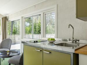 a kitchen with a sink and a large window at Holiday Home Hölick Minichalet Plus 7 by Interhome in Hudiksvall +32 photos