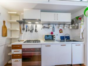 une cuisine avec des armoires blanches et une cuisinière dans l'établissement Holiday Home delle Rose by Interhome, à Livourne