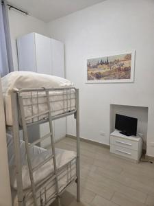 a bedroom with a bunk bed and a television at Appartamento Morelli Beach - Via Fratti 2 in Follonica