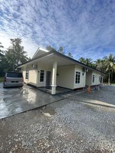 a house with a car parked in front of it at Anjang Pat Kesang Laut Homestay in Gua Sai