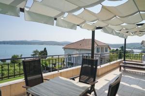 a balcony with a table and chairs and a view of the water at Six bedroom luxury villa with private pool in quiet residential area near beaches in Sozopol