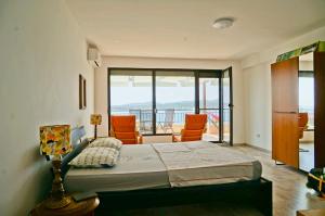 a bedroom with a large bed and a balcony at Six bedroom luxury villa with private pool in quiet residential area near beaches in Sozopol