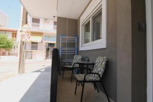 a table and chairs on the side of a building at Oropos Central Living in Néa Palátia