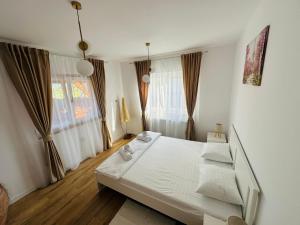 a bedroom with a bed with white sheets and pillows at Mountain View House Brasov in Braşov
