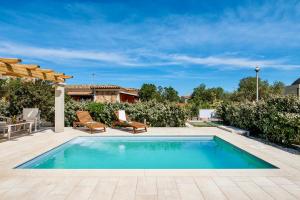 a swimming pool with two chairs and a house at Villa with private pool in San Teodoro just few minutes from La Cinta - beach in San Teodoro