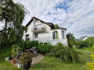 a white house with a balcony and some plants at Eifel-FeWo by Eva Kröll in Manderscheid