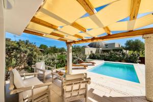 a patio with a pool and chairs and a pergola at Villa with private pool in San Teodoro just few minutes from La Cinta - beach in San Teodoro +20 photos