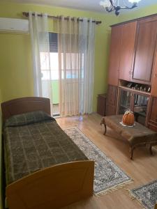 Un dormitorio con una cama y una silla y una ventana. en City Center, en Durrës