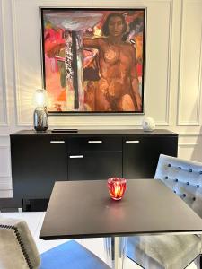 ein Wohnzimmer mit einem Tisch und einem Gemälde an der Wand in der Unterkunft Le jardin secret du jardin gourmand in Auxerre