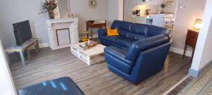 a living room with a blue couch and a fireplace at L'espÉrance 2 in Haybes