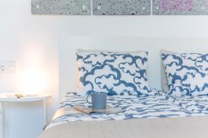 a blue and white bed with a cup on a plate at Studio Fantastico 1 in Puerto de la Cruz