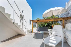 a patio with a white chair and an umbrella at Studio Fantastico 1 in Puerto de la Cruz