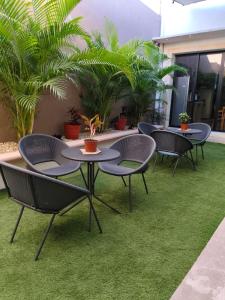 a group of tables and chairs on a lawn with plants at Habitación compartida para mujeres in Mérida