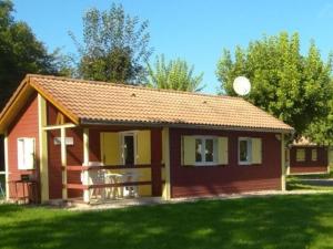 a small red and yellow house in a yard at Chalet Edelweiss au cœur de la nature vosgienne - FR-1-583-441 in Mélisey