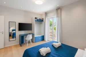 マッサ・ルブレンセにあるMaison le Sirene - Apartmentのベッドルーム1室(ブルーベッド1台、タオル付)