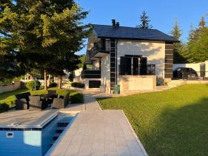 a house with a swimming pool in the yard at Vila Botanic Residence in Sarajevo