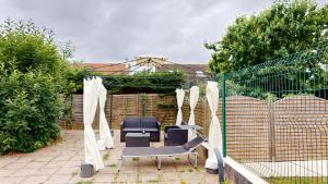a patio with two chairs and a fence at Kimia Suite Room in Osny