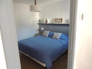 a bedroom with a bed with blue sheets and pillows at côte et mer in Sainte-Adresse