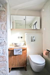 a bathroom with a white toilet and a sink at Villa Kuk in Bol