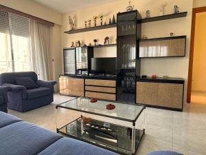 a living room with a couch and a glass coffee table at Tropicana in Benicàssim