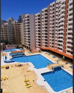 a large swimming pool in front of some buildings at Praia da Rocha Apartamento Costa Azul in Portimão