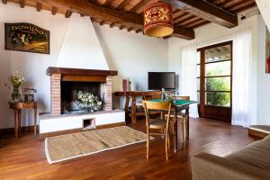 a living room with a fireplace and a table at Podere Pontassala in Palaia
