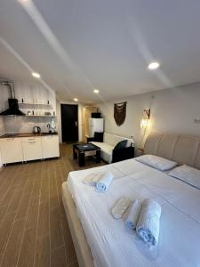 a hotel room with a large white bed and a kitchen at Woodland Borjomi in Borjomi
