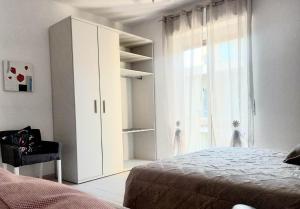 a bedroom with a white cabinet and a window at La casa dei Sogni e dintorni in Cervo