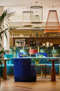 a lobby with blue chairs and tables at Hotel Giacomo Morra Alba - Handwritten Collection in Alba