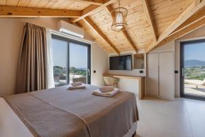 a bedroom with a large bed and large windows at Cameo Luxury Villas in Laganas +100 photos