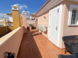 einen Balkon mit einer weißen Tür an einem Haus in der Unterkunft Casa a 200m de la playa en San Juan de los Terreros - ES-376-12 in Pulpí