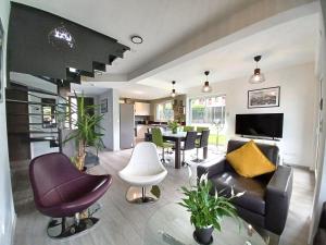 ein Wohnzimmer mit Sofa, Stühlen und einem Tisch in der Unterkunft Maison neuve 4 chambres à Soulzbach - FR-1-744-46 in Soultzbach-les-Bains