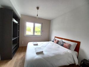 ein Schlafzimmer mit einem großen weißen Bett mit einem Fenster in der Unterkunft Maison neuve 4 chambres à Soulzbach - FR-1-744-46 in Soultzbach-les-Bains