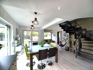 eine Küche und ein Wohnzimmer mit einem Tisch und einer Wendeltreppe in der Unterkunft Maison neuve 4 chambres à Soulzbach - FR-1-744-46 in Soultzbach-les-Bains