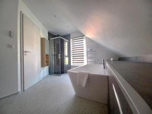 ein weißes Badezimmer mit Badewanne und Waschbecken in der Unterkunft Maison neuve 4 chambres à Soulzbach - FR-1-744-46 in Soultzbach-les-Bains + 27 Fotos