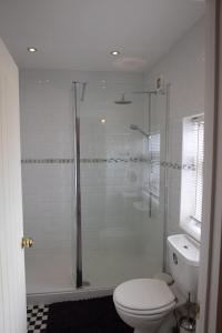 a bathroom with a toilet and a glass shower at Cottage in Central Burbage Leicestershire in Burbage