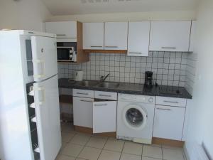 a kitchen with white cabinets and a washing machine at Pavillon confortable dans la Vallée de l'Ognon - FR-1-583-413 in Larians-et-Munans