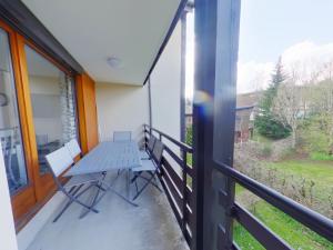 eine Veranda mit einem Tisch und Stühlen auf dem Balkon in der Unterkunft Appartement 2 chambres avec balcon près des pistes aux Rousses - FR-1-834-2 in Les Rousses