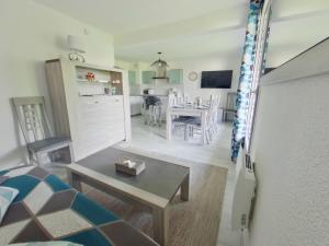 ein Wohnzimmer mit Tisch und ein Esszimmer in der Unterkunft Appartement 2 chambres avec balcon près des pistes aux Rousses - FR-1-834-2 in Les Rousses + 2 Fotos