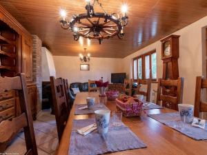a dining room with a table and a chandelier at Gîte chaleureux dans les Vosges avec cheminée - FR-1-583-437 in Belfahy