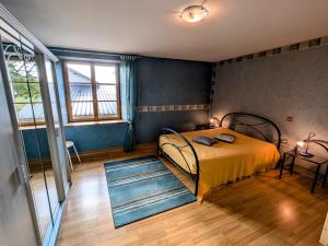a bedroom with a bed with yellow sheets and blue walls at Maison spacieuse près de Vesoul avec cheminée, idéale pour familles - FR-1-583-434 in Dampierre-sur-Linotte