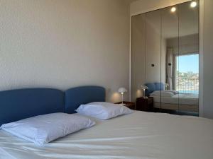 una camera da letto con un letto con lenzuola bianche e uno specchio di Maison Méditerranéenne 2 Pers avec Garage - FR-1-225C-178 a Banyuls-sur-Mer