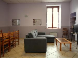 a living room with a couch and a table at Gîte Authentique dans le Parc Régional, Animaux Acceptés - FR-1-583-464 in La Montagne