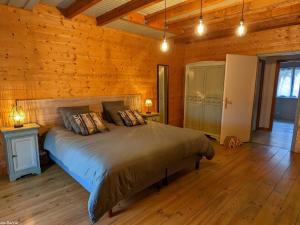 a bedroom with a bed in a wooden cabin at Gîte paisible dans une ancienne ferme avec WIFI et parking à Saint-Bresson - FR-1-583-440 in Saint-Bresson