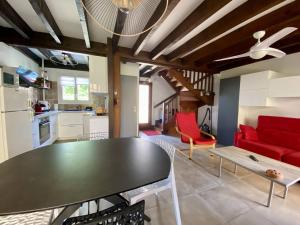 a living room with a table and a red couch at Maison mitoyenne charmante, 3 pièces, 4 pers., parking, wifi, près centre-ville - FR-1-495-152 in Cambo-les-Bains