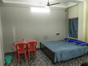 a bedroom with a bed and a table and chairs at Indi Nest in Agartala