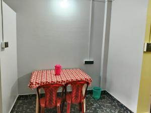 a table with red chairs and a red cup on it at Indi Nest in Agartala