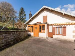 a white house with a stone wall and a driveway at Maison de charme à Fougerolles, idéale pour curistes - FR-1-583-397 in Fougerolles